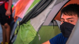 Migrante en un campamento en Tijuana