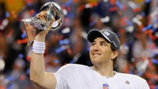 Quarterback Eli Manning #10 of the New York Giants celebrates holding up the Vince Lombardi Trophy after they defeated the New England Patriots in Super Bowl XLVI February 5, 2012