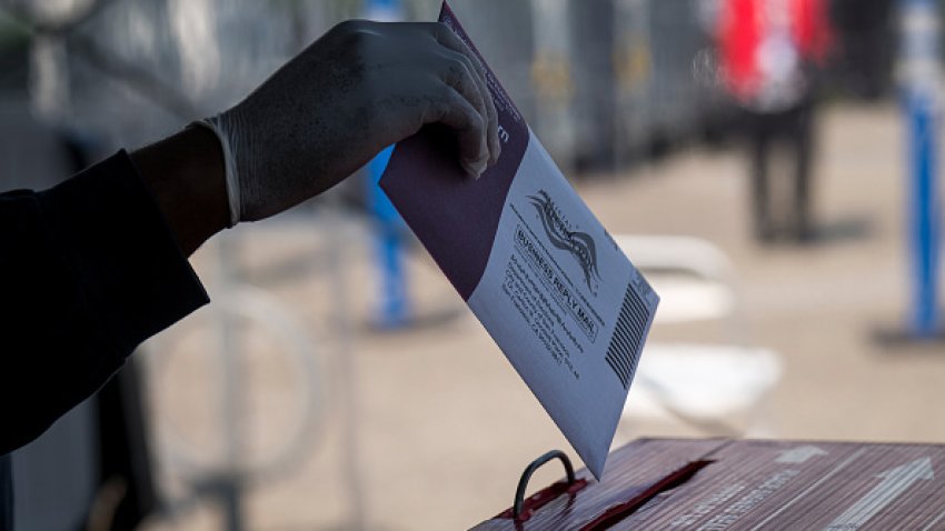 A resident wearing a protective glove drops a ballot into a ballot box at an early voting polling location for the 2020 Presidential election in San Francisco, California, U.S., on Tuesday, Oct. 6, 2020.  Photographer: David Paul Morris/Bloomberg via Getty Images