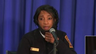 Woman speaks into a microphone sitting down