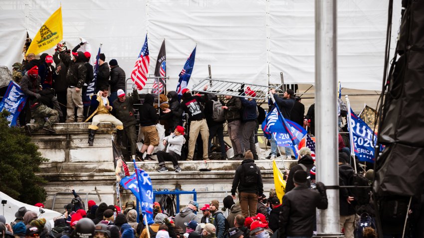 WASHINGTON, DC – JANUARY 06: A group of pro-Trump protesters climb the walls of the Capitol Building after storming the West lawn on January 6, 2021 in Washington, DC. A pro-Trump mob stormed the Capitol, breaking windows and clashing with police officers. Trump supporters gathered in the nation’s capital today to protest the ratification of President-elect Joe Biden’s Electoral College victory over President Trump in the 2020 election.