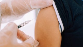 A close-up view of a vaccination of a male toddler in the hospital ward