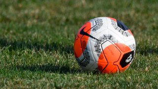 A soccer ball sits on a grass field