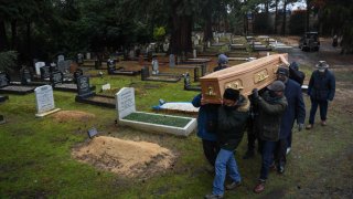 Una víctima del COVID-19 es enterrada en un cementerio en el reino Unido, el martes.