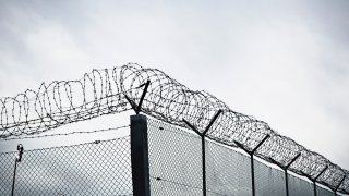 Chain link fence with barbed wire and razor wire.