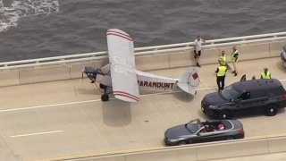A plane lands on a bridge
