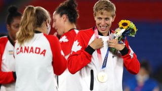 Quinn wears their gold medal after Team Canada's soccer victory