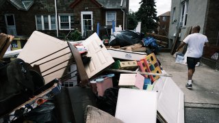 A person sorts through belongings from their flooded home in a Queens neighborhood