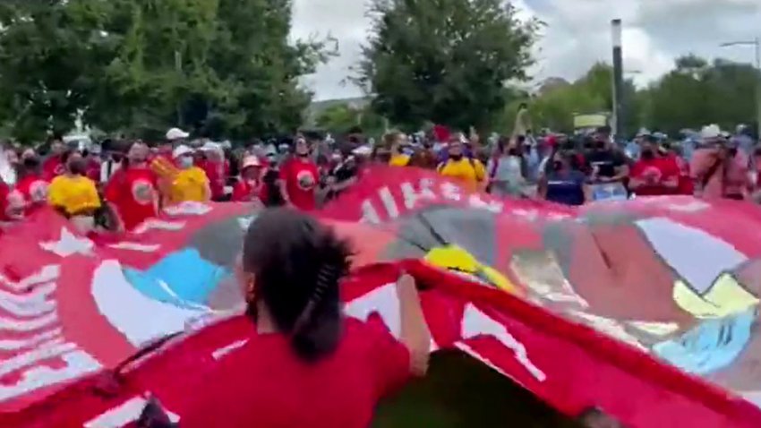 personas moviendo una bandera durante una marcha