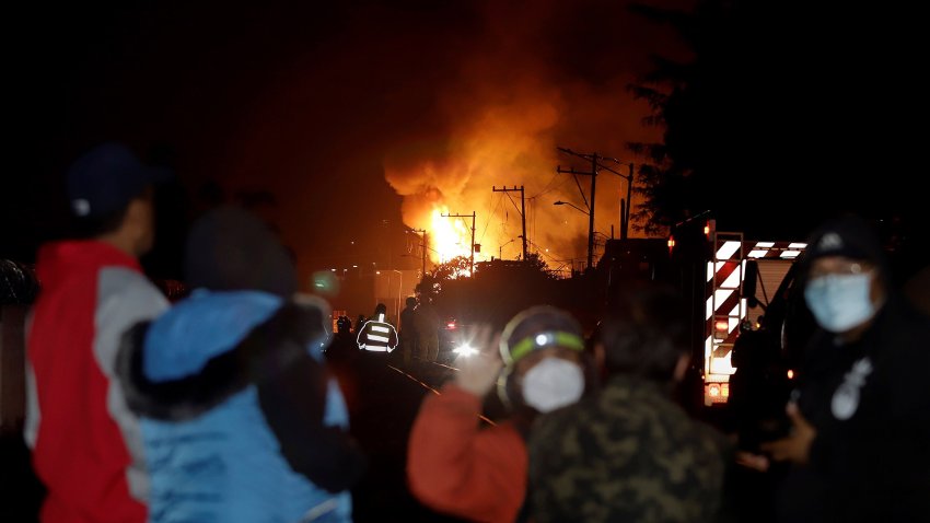 Personas observan el área donde se registró una explosión e incendio, la madrugada de este domingo, en el municipio de San Pablo Xochimehuacán, en el estado de Puebla (México). EFE/Hilda Ríos