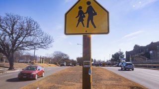 Traffic drives past Sunset High School on West Jefferson Boulevard. Traffic accidents dropped 82% after the city narrowed the roadway from three to two lanes in each direction.