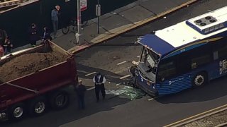 Glass shards cover the road after an MTA bus and dump truck collided.