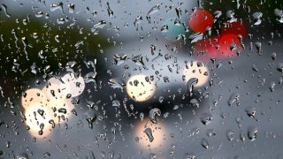 Car headlights behind rain droplets