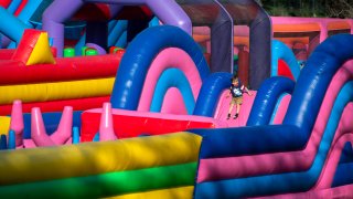 A child playing on a slide in a bounce house.