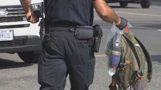 Un oficial retira un cóctel molotov en una bolsa