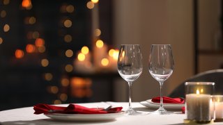 Foto de una mesa con copas de vino vacia y velas