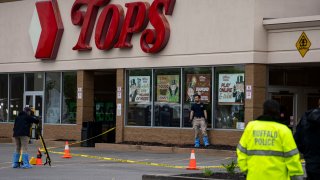 Bullet holes are seen in the window of Tops Friendly Market at Jefferson Avenue and Riley Street, as federal investigators work the scene of a mass shooting on Monday, May 16, 2022 in Buffalo, NY. (Kent Nishimura / Los Angeles Times via Getty Images)