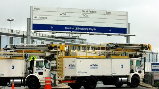 Maintenance trucks guard the entrance to Terminal Two at John F. Kennedy International Airport in New York 14 September, 2001. New York City airports remain closed due to continued security concerns. AFP PHOTO/Henny Ray ABRAMS (Photo credit should read HENNY RAY ABRAMS/AFP via Getty Images)