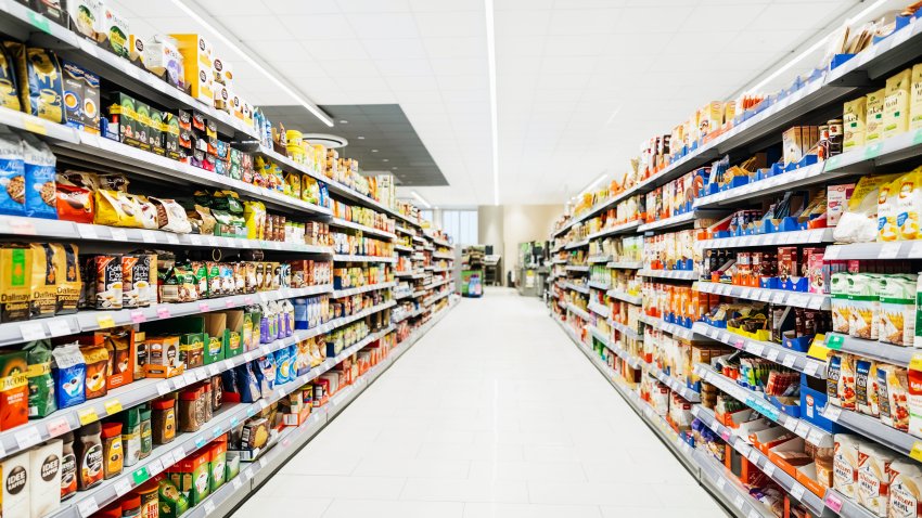 A colorful supermarket aisle withe no people but an abundance of food.