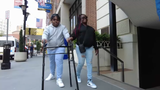 Jayshawn Boyd walks the sidewalk with his mother.