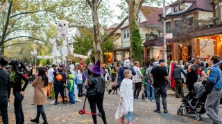People give out candy during the Halloween block party at 4th Street in the Kensington neighborhood in Brooklyn on October 31, 2022 in New York City.