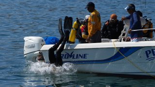 Buzos se lanzan tras la búsqueda de marineros desaparecidos tras el paso del huracán Otis en Acapulco a finales de octubre pasado.