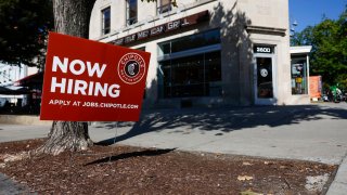 A “Now Hiring” sign is displayed in front of a Chipotle restaurant on October 7, 2022 in Washington, DC.