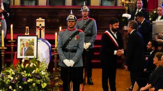 El presidente de Chile, Gabriel Boric, en el centro, le da la mano al exmandatario chileno Eduardo Frei junto al ataúd del fallecido presidente chileno Sebastián Piñera durante su velorio en el Congreso en Santiago, Chile, el viernes 9 de febrero de 2024.