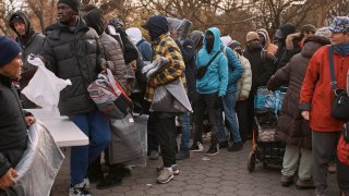 Migrantes toman mantas cerca de un Centro de Ayuda a Migrantes en Nueva York, en una imagen de archivo.