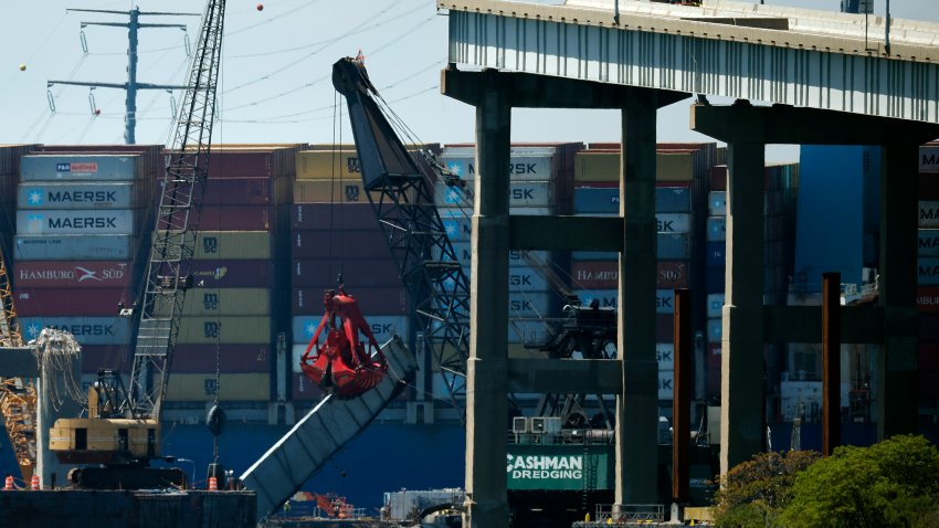 BALTIMORE, MARYLAND – APRIL 26: Salvage crews use cranes to remove wreckage of the Key Bridge from the bottom of the Patapsco River one month after the cargo ship Dali (background) collided with the bridge on April 26, 2024 in Baltimore, Maryland. A temporary channel opened this week to allow ships stuck in the Port of Baltimore to leave, four weeks after the maritime accident.  (Photo by Chip Somodevilla/Getty Images)