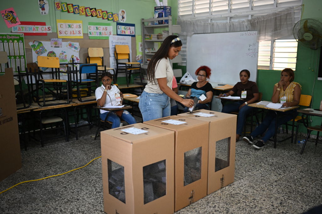 Una mujer deposita su voto en un colegio electoral durante las elecciones generales en Santo Domingo el 19 de mayo de 2024. Las urnas se abrieron en la República Dominicana el domingo, donde el presidente Luis Abinader se prepara para una cómoda reelección gracias al apoyo generalizado a su postura dura. sobre la migración desde el problemático vecino Haití. (Foto de Federico PARRA/AFP) (Foto de FEDERICO PARRA/AFP vía Getty Images)