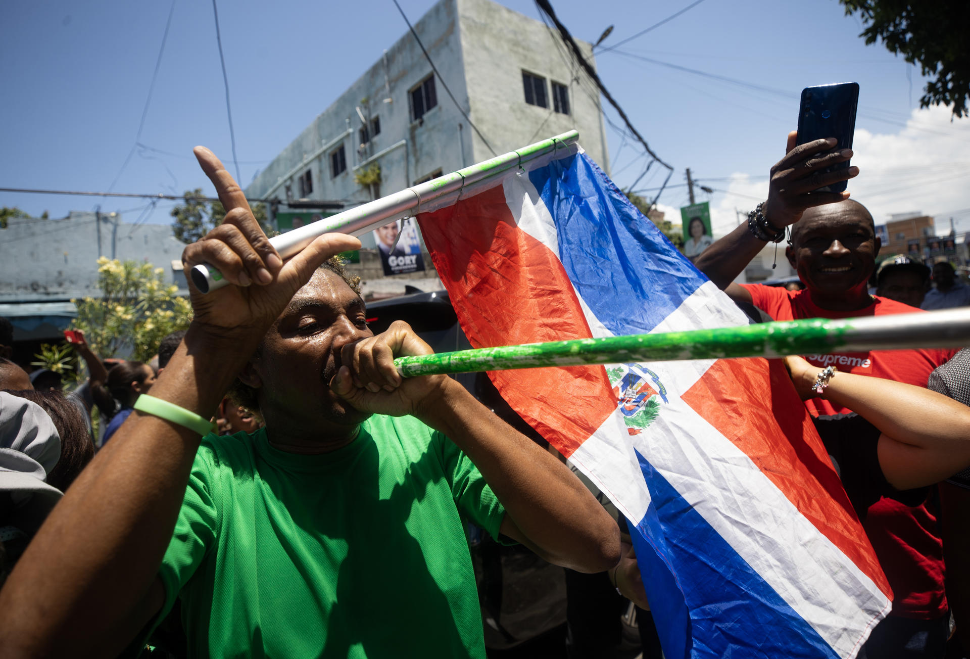 Simpatizantes del expresidente dominicano Leonel Fernández, candidato presidencial del partido Fuerza del Pueblo, lo acompañan durante su votación este domingo en Santo Domingo (República Dominicana). En esta jornada, a la que están convocados 8,1 millones de votantes, se elegirá al presidente del país, al vicepresidente y los miembros del Congreso bicameral (32 senadores y 190 diputados), así como 20 representantes dominicanos en el Parlamento Centroamericano (Parlacen). EFE/ Orlando Barría