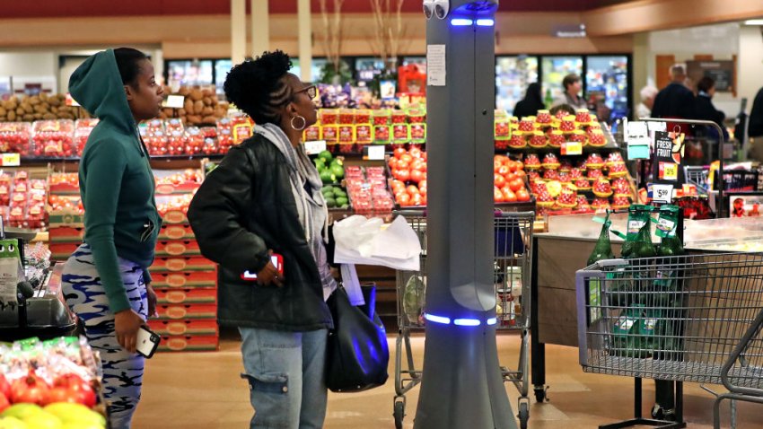 QUINCY, MA – MAY 17: Kierra Cook, left, and her mother Regina Waters react to Marty, a robot on duty at Stop & Shop in Quincy, MA on May 17, 2019. Marty is 140 pounds of plastic and metal, with glowing lights atop a towering frame with big cartoon eyes, and cameras and lasers to spot garbage, spills, and other stuff that shouldnt be in the aisles of a supermarket. The $35,000 machine is one of about 500 robots that Stop & Shops owner, the Dutch company Ahold Delhaize, has deployed in some of its US grocery stores. And in the process, Ahold is doing its part to normalize robots in public places. The robot is in the vanguard of an army of machines that will make casual run-ins with robots commonplace in store aisles, on sidewalks, and in other public places. (Photo by David L. Ryan/The Boston Globe via Getty Images)