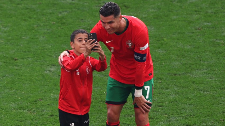 DORTMUND, GERMANY – JUNE 22: Cristiano Ronaldo of Portugal takes a selfie with a young pitch invader during the UEFA EURO 2024 group stage match between Turkiye and Portugal at Football Stadium Dortmund on June 22, 2024 in Dortmund, Germany. (Photo by Kevin C. Cox/Getty Images)