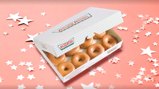 A dozen Krispy Kreme donuts in a box.