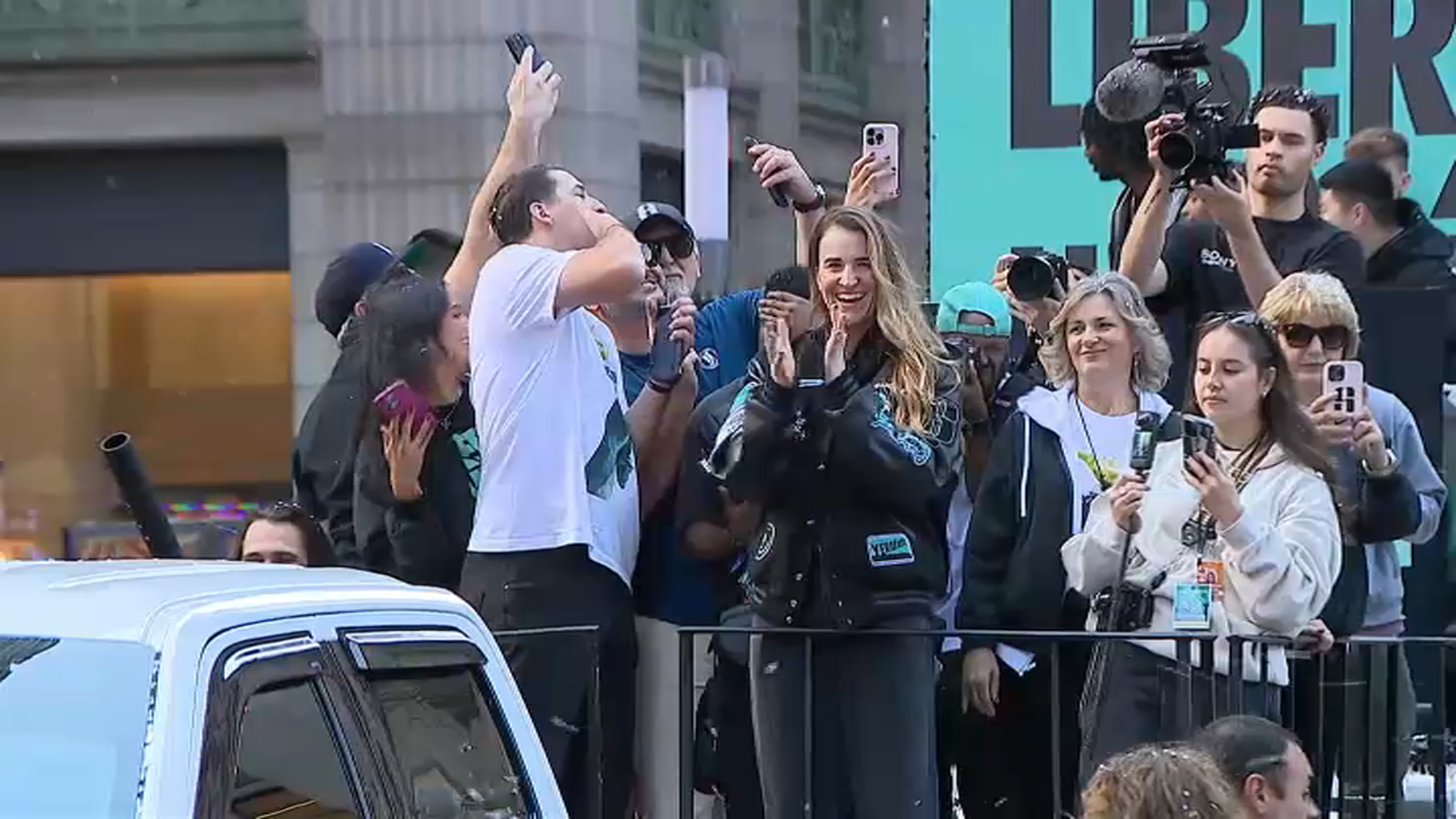 La jugadora estrella de New York Liberty, Sabrina Ionescu, saluda a los fanáticos y celebra en una carroza del desfile.