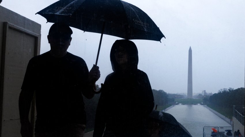 Tourists are seen on the National Mall during heavy rain from tropical storm Debby in Washington, District of Columbia. (Photo by Aaron Schwartz / Middle East Images / Middle East Images via AFP) (Photo by AARON SCHWARTZ/Middle East Images/AFP via Getty Images)