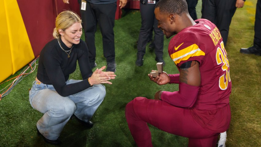 LANDOVER, MARYLAND – DECEMBER 29: Mikaela Worley accepts the proposal from safety Jeremy Reaves #39 of the Washington Commanders on the field following an NFL football game against the Atlanta Falcons at Northwest Stadium on December 29, 2024 in Landover, Maryland. (Photo by Todd Rosenberg/Getty Images)