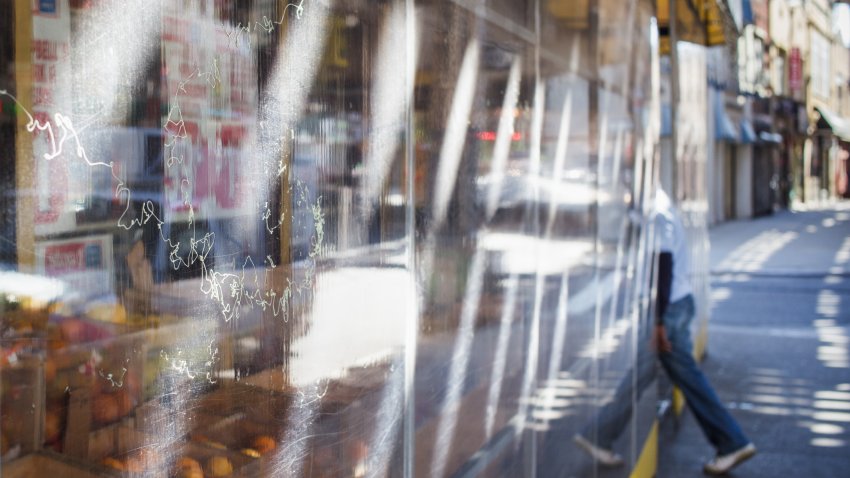 reflection of a man entering a bodega in New York