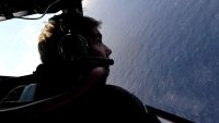 IN FLIGHT – APRIL 11: Co-pilot and Squadron Leader Brett McKenzie of the Royal New Zealand Airforce (RNZAF) P-3K2-Orion aircraft, helps to look for objects during the search for missing Malaysia Airlines flight MH370 in flight over the Indian Ocean on April 13, 2014 off the coast of Perth, Australia. Search and rescue officials in Australia are confident they know the approximate position of the black box recorders from missing Malaysia Airlines Flight MH370, Australian Prime Minister Tony Abbott said on Friday. At the same time, however, the head of the agency coordinating the search said that the latest “ping” signal, which was captured by a listening device buoy on Thursday, was not related to the plane.  (Photo by Greg Wood – Pool/Getty Images)