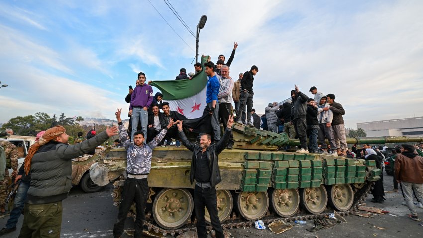 TOPSHOT – People celebrate with anti-government fighters at Umayyad Square in Damascus on December 8, 2024. Islamist-led rebels declared that they have taken Damascus in a lightning offensive on December 8, sending President Bashar al-Assad fleeing and ending five decades of Baath rule in Syria. (Photo by LOUAI BESHARA / AFP) (Photo by LOUAI BESHARA/AFP via Getty Images)