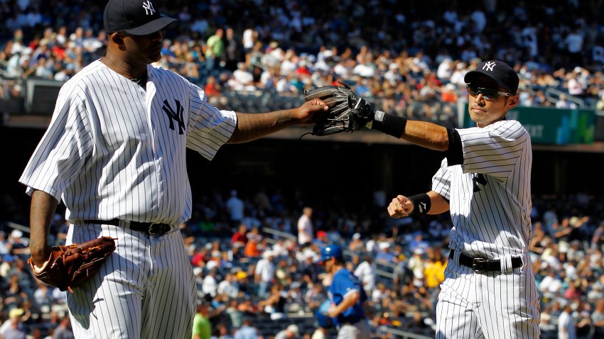 NEW YORK – AUGUST 29:  CC Sabathia #52 greets Ichiro Suzuki #31 of the New York Yankees after an inning-ending catch against the Toronto Blue Jays during their game at Yankee Stadium on August 29, 2012 in the Bronx Borough of New York City.  (Photo by Jeff Zelevansky/Getty Images)