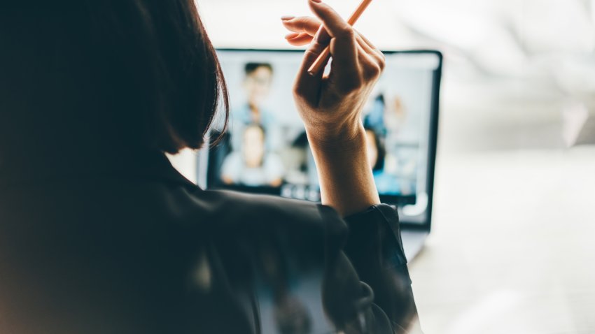 Young working woman talking on video call via laptop.