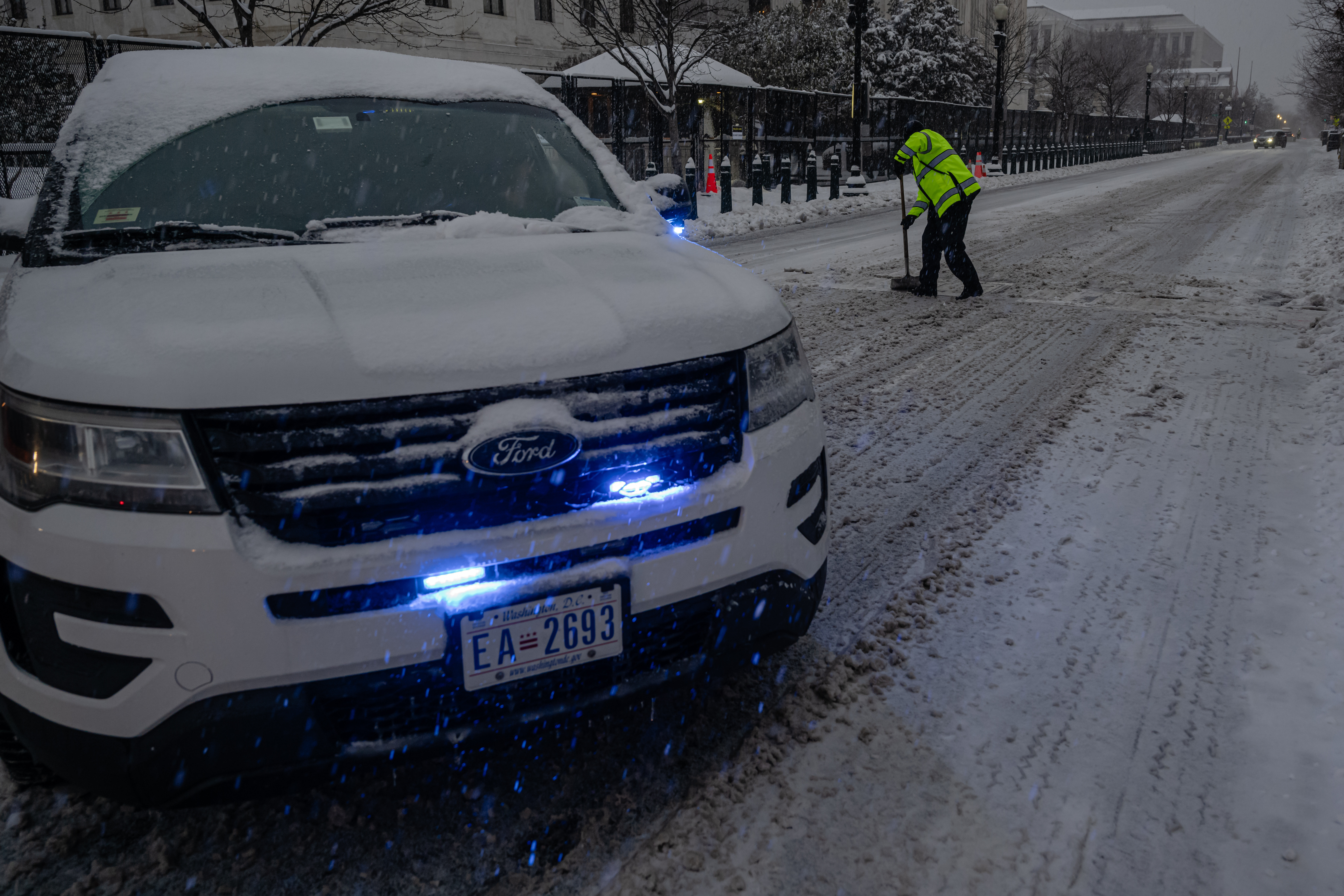 WASHINGTON, DC - 6 DE ENERO: Un vehículo de la policía bloquea la carretera cerca del Capitolio de EEUU mientras un miembro de la policía del Capitolio quita la nieve el 6 de enero de 2025 en Washington, DC. Se están llevando a cabo preparativos de seguridad reforzados para la próxima certificación del voto electoral del 6 de enero, el funeral de Estado del presidente Carter y la inauguración. (Foto de Jon Cherry/Getty Images)