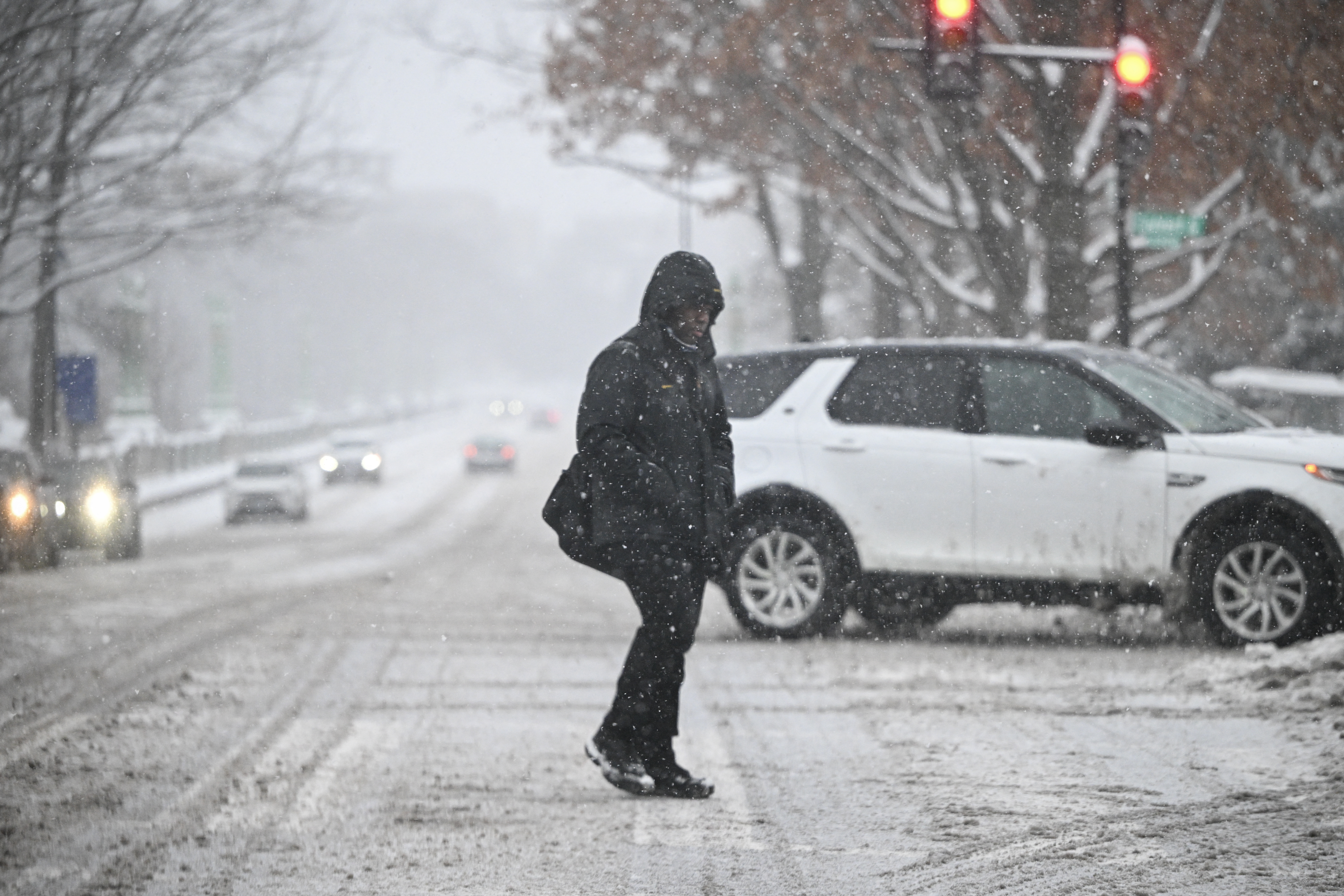 Un peatón cruza la calle mientras cae nieve durante una tormenta invernal en Washington, DC, el 6 de enero de 2025. Peligrosas condiciones invernales están afectando a una gran franja del centro y el este de Estados Unidos, como un sistema de tormenta severa sigue la pista hacia el este, lo que provocó interrupciones de viaje y de trabajo de Kansas City a Washington. (Foto de Mandel NGAN / AFP) (Foto de MANDEL NGAN/AFP vía Getty Images)