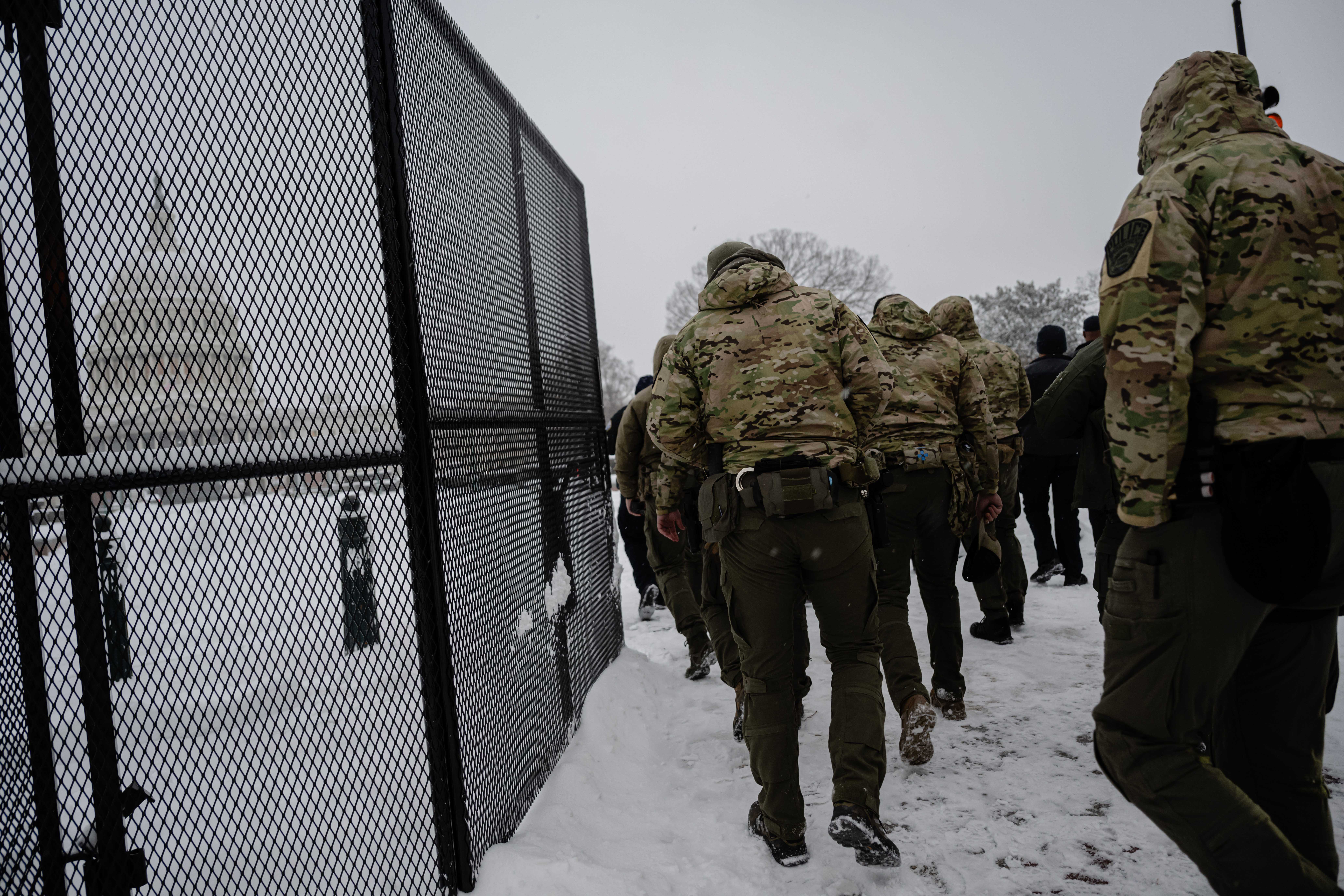 WASHINGTON, DC - 6 DE ENERO: Miembros de la policía entran en el vallado de seguridad que rodea el Capitolio de EEUU durante una tormenta de nieve el 6 de enero de 2025 en Washington, DC. Se están llevando a cabo preparativos de seguridad reforzados para la próxima certificación del voto electoral del 6 de enero, el funeral de Estado del presidente Carter y la inauguración. (Foto de Jon Cherry/Getty Images)