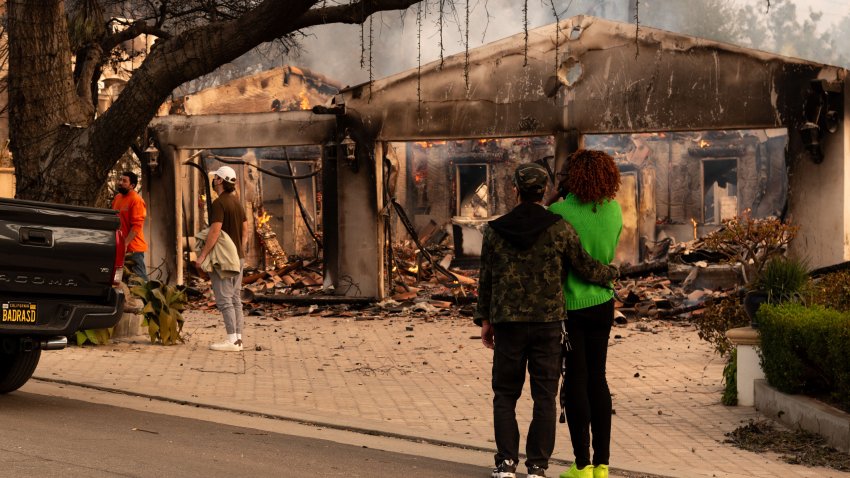 ACOMPAÑA CRÓNICA EEUU INCENDIOS USA9963. ALTADENA (ESTADOS UNIDOS), 08/01/2025.- Personas observan una casa afectada por un incendio este miércoles, en Altadena, California (Estados Unidos). Varios residentes afectados por los históricos incendios de Los Ángeles han desobedecido las órdenes de evacuación para tratar de salvar sus viviendas, aunque para muchos es muy poco lo que pueden hacer sin asistencia de los bomberos que se han visto superados por la emergencia. EFE/ Ana Milena Varón