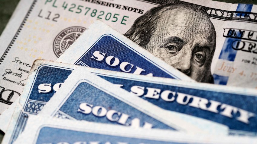 Several Social Security Cards on a US United States one hundred dollar bill $100 system of benefits for retired elderly people