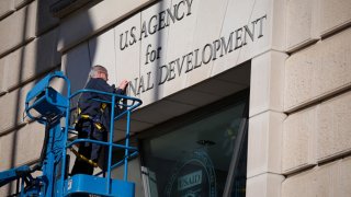 Un trabajador remueve el cartel en la oficina de la Agencia de USAID en Washington, DC, días pasados.