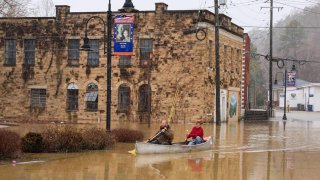 Dos hombres en aguas inundadas en Kentucky.